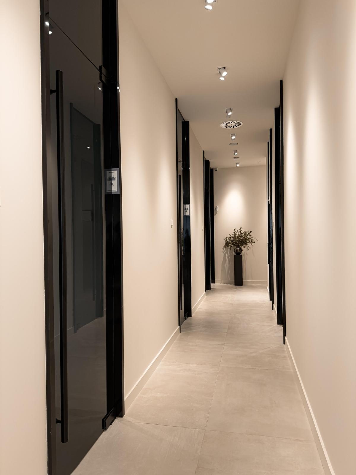 Pasillo de la clínica con puertas de vidrio oscuro